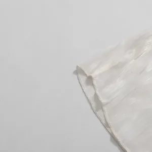Macro close-up detail showing white pleated fabric hem with fine overlock stitching