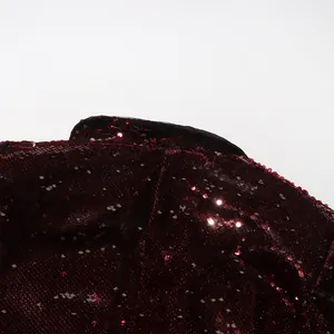 Close-up macro detail of dark red shimmering sequins on a women's fashion blazer jacket
