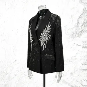 Detailansicht eines schwarzen Blazers mit aufwendigen Strassmustern auf einer Schaufensterpuppe.