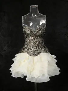 Elegantes Set aus schwarzem Spitzen-Corsagen-Top und cremefarbenem Rüschenrock