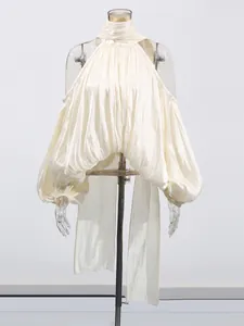 Élégante blouse crème à col licou et épaules dénudées avec manches bouffantes et nœud.