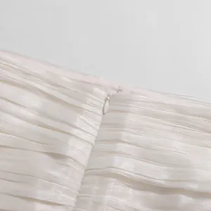 Close-up detail of white pleated fabric with hidden zipper for elegant French style skirt