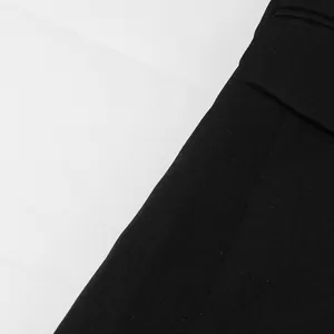 Close-up detail showing the high-quality texture and pocket flap of a black women's blazer