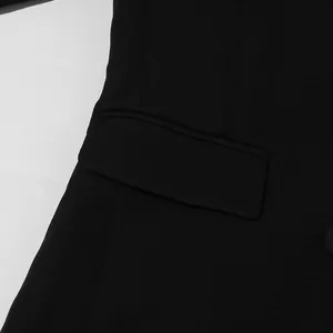 Macro view of black blazer jacket pocket detail showing premium fabric textures.