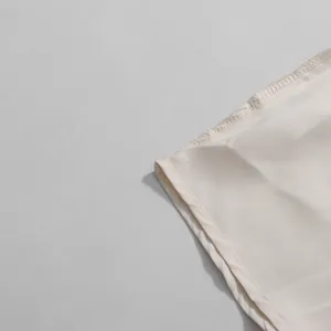 Detailed close-up of neat stitching and high-quality satin fabric on beige French skirt