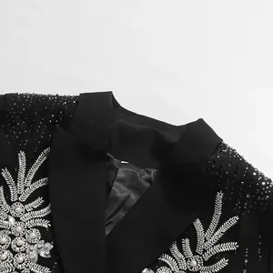 Detail eines luxuriösen schwarzen Blazers mit schwerer Strass- und Perlenstickerei.