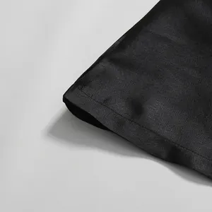 Nahaufnahme des schwarzen Rockstoffs mit strukturierter Webart und Saumnahtdetails.