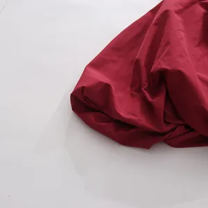Vista dettagliata della trama e delle pieghe di una gonna minimalista rosso scuro