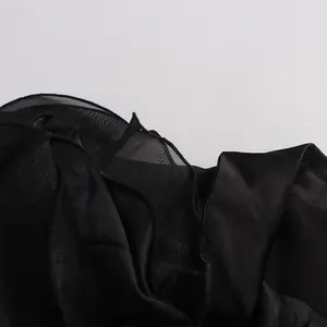 Detailansicht eines luxuriösen schwarzen Blazers mit Netzrüschen und schimmernder Stofftextur