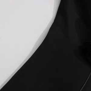 Makro-Detailaufnahme des glatten schwarzen Stoffes und des geschwungenen Ausschnitts des Blazers
