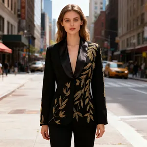 Detail view of a luxury black blazer with intricate gold leaf embroidery on the street.