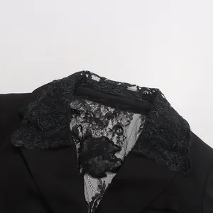 Detail view of intricate floral lace embroidery on black blazer collar and back panel.