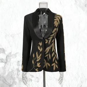 Detail of luxury black blazer featuring heavy gold leaf embroidery and deep V-neckline.