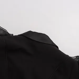 Nahaufnahme eines schwarzen Blazers mit rüschenartigen Lotusblatt-Verzierungen.