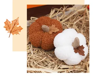 Close-up detail of plush pumpkin ornaments in orange and white for autumn harvest decor