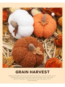 A detailed view of plush decorative Halloween pumpkins on straw for harvest festival theme