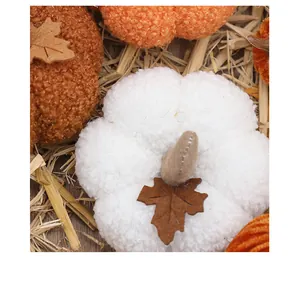 Detail view of plush white pumpkin with soft sherpa texture and felt leaf decor