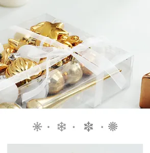 Close-up of 34-piece gold and white Christmas ornament set in transparent gift box.
