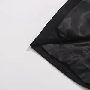 Detail shot of the smooth satin lining and textured outer fabric of the black blazer.