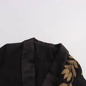 Detailed view of the luxury gold leaf embroidery on the collar of a black blazer