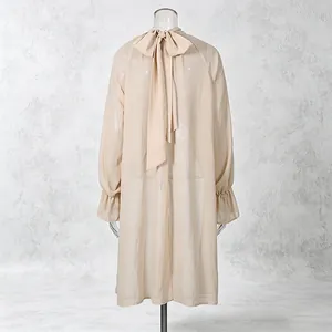 Elegant apricot sheer chiffon blouse back view featuring large bow tie and ruffled cuffs