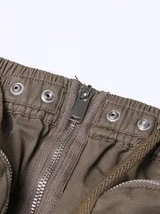 Macro view showing the sturdy metal zipper and button details on a high-waisted midi skirt