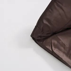 Primer plano del forro de satén marrón liso de una chaqueta de invierno acolchada premium.