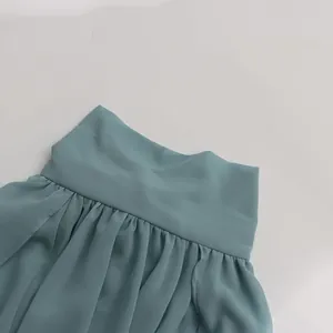 Detail view of a French style casual blouse with an irregular stand collar in teal blue.