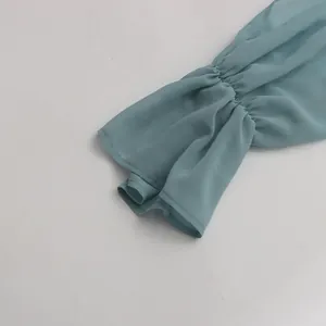Detailed view of elegant ruffled cuffs on a light blue French style chiffon shirt