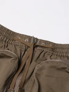 Close-up detail of high-waisted khaki cargo skirt featuring drawstring and metal zipper