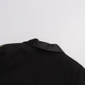 Close-up detail of a luxury black blazer featuring exquisite gold embroidery and a satin lapel.