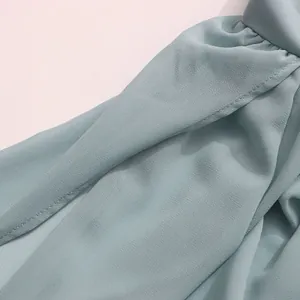 Detailed macro view of light blue chiffon blouse fabric with neat stitching quality