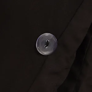Close-up of a translucent button on a high-quality black tailored suit jacket.