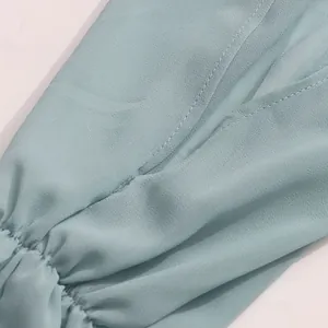 Macro view showing the neat stitching and elastic cuff of a light blue French blouse sleeve