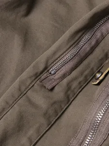 Macro detail showing heavy-duty metal zippers and premium twill fabric on khaki skirt