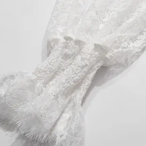 Dettaglio del polsino in pizzo floreale di una camicetta bianca in stile francese