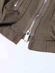 Close-up detail showing a heavy-duty silver metal zipper on brown cotton twill skirt