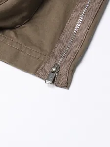 Close-up detail of metal zipper and khaki twill fabric on a high-waisted skirt.