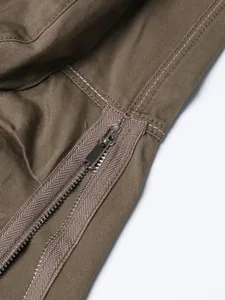 Detailed view of the silver-toned metal zipper on a khaki twill high-waisted midi skirt
