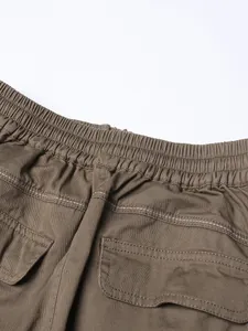 Close-up view of elastic waistband and flap pockets on khaki high-waisted skirt detail