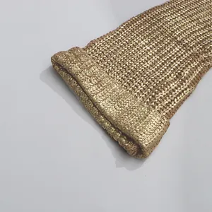 Nahaufnahme der hochwertigen goldfarbenen Strickstruktur aus Metallic-Garn am Pulloverärmel