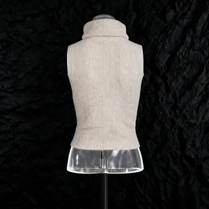 Back view of a beige sleeveless turtleneck knitted vest on a black textured background
