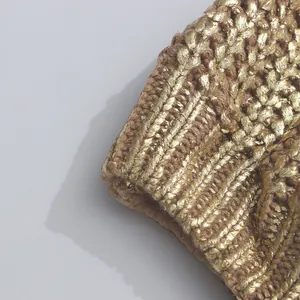 Nahaufnahme von goldenem Metallstrickgewebe mit detaillierter Textur und Rippbündchen