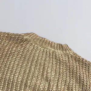 Nahaufnahme des goldenen grob gestrickten Pullover-Ausschnitts mit Metallic-Struktur