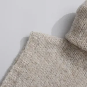 Detailed macro view of high-quality marled beige knitted turtleneck sweater texture
