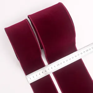 Close-up detail of burgundy velvet ribbons with a ruler measuring specific widths