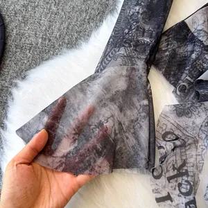 Primo piano del tessuto in rete tie-dye trasparente con design a manica a campana.