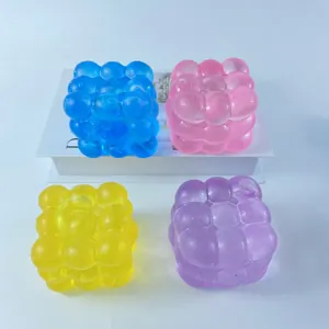 Vue détaillée des jouets à presser en forme de cube à bulles bleu, rose, jaune et violet