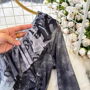 Dettaglio della maglietta retro tie-dye con volant e stampa di giornale