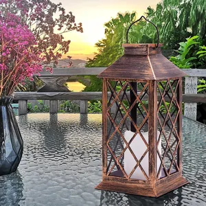 Vintage bronze solar garden lantern with LED candle on glass table at sunset outdoors